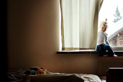 Girl sitting on bed at home