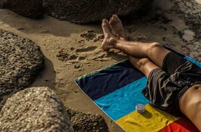 Low section of man relaxing on beach