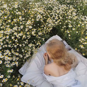 High angle view of woman relaxing on white flowering plants