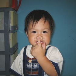 Portrait of cute smiling boy touching nose