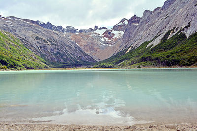 Scenic view of lake by mountains against sky