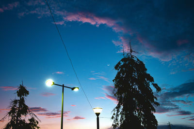 Low angle view of illuminated street light against sky at sunset