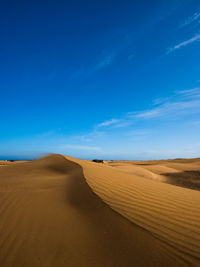 Scenic view of desert against blue sky