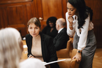 Female financial advisors discussing over document in office