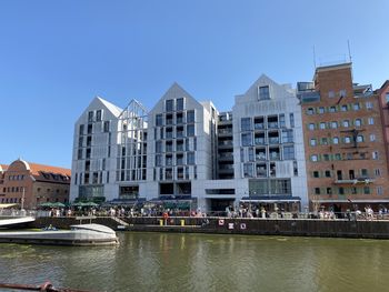 Buildings by river against sky