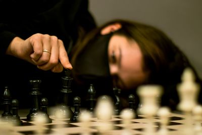 Defocused image of woman wearing mask playing chess