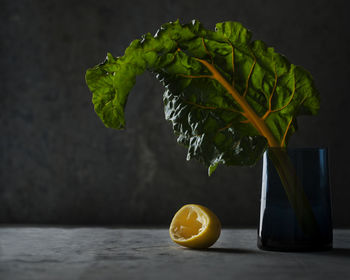 Leaf vegetables and lemon peel on table