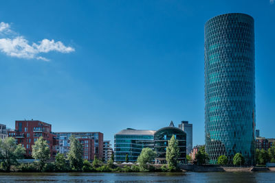 Low angle view of skyscrapers against blue sky