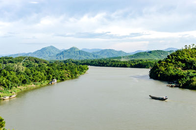 Scenic view of river amidst trees against sky