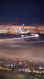 High angle view of illuminated buildings against sky at night