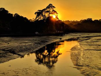 Scenic view of lake against clear sky during sunset