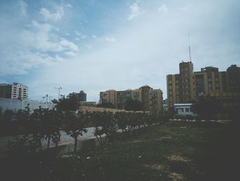 View of cityscape against cloudy sky