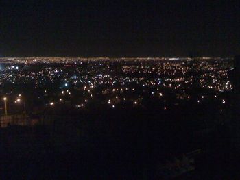 Illuminated cityscape against sky at night