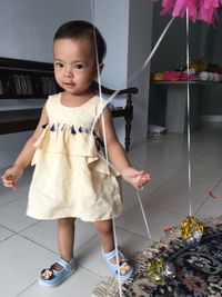 Full length of cute girl standing on floor at home