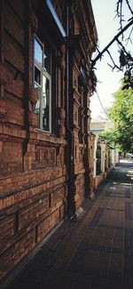 Footpath by old building against sky