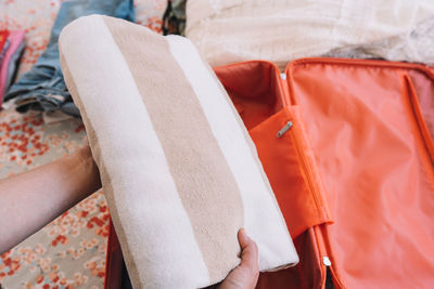 Cropped hand of woman packing bag