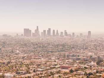 Aerial view of buildings in city against clear sky