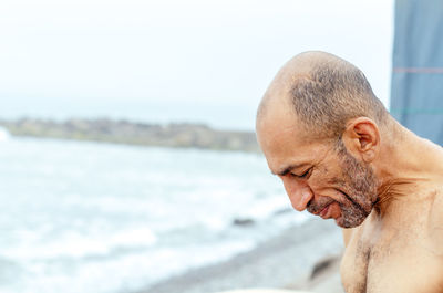 Portrait of shirtless man in sea
