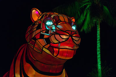Close-up of illuminated lighting equipment against black background