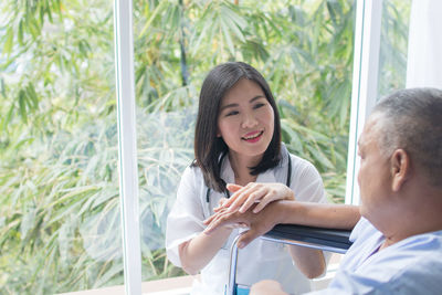 Portrait of a smiling young woman holding window