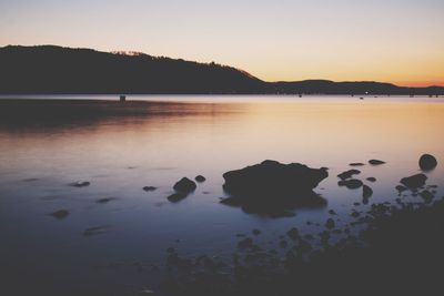 Scenic view of calm lake at sunset