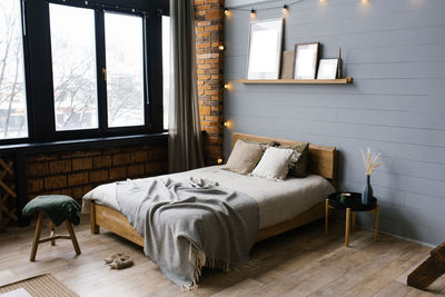 Double bed with natural natural accents on the sheets and beige pillows in the grey scandinavian 