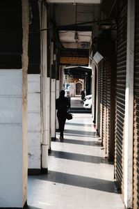 Rear view of woman walking in corridor of building