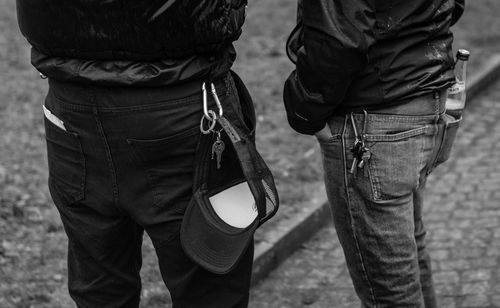 Midsection of friends standing on footpath