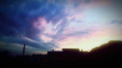 Silhouette of city against dramatic sky