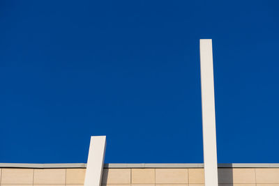 Abstract architectural detail of a modern office building facade isolated with blue sky background.