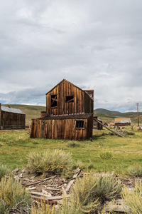 Old barn on field against sky