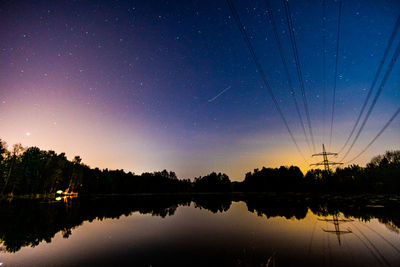 Scenic view of lake against sky at night