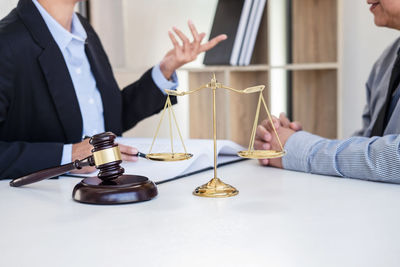 Midsection of man holding paper while standing on table