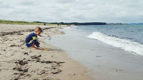 Full length of boy playing on beach