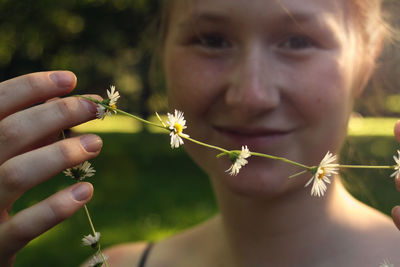 Close-up of young woman holding flower