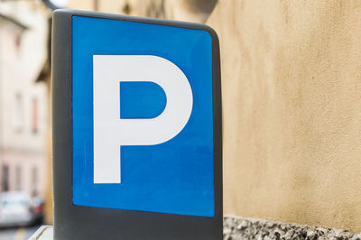Close-up of parking sign against wall