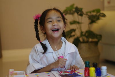 Portrait of a smiling girl holding table