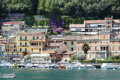 Boats moored in canal against buildings in city