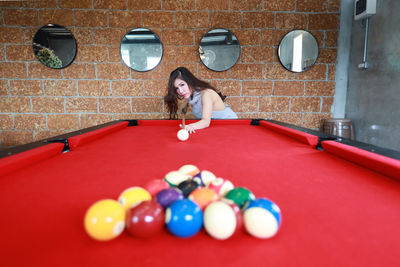 Young woman playing with ball on table