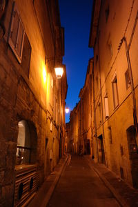 Narrow alley along buildings at night
