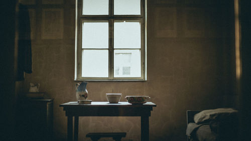 Crockery on table by window at home