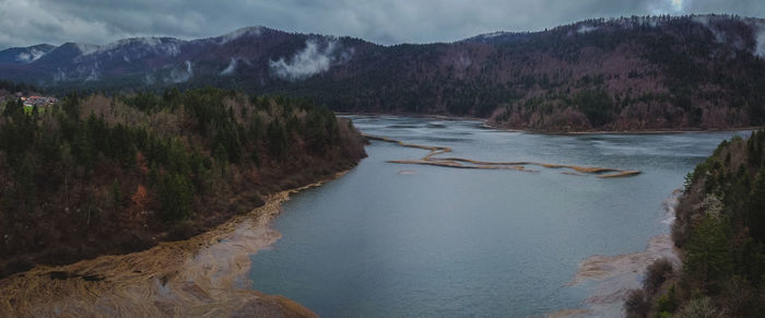 Scenic view of river amidst mountains against sky
