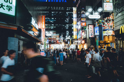 People walking on city street at night