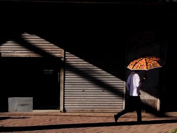 Rear view of woman standing against built structure