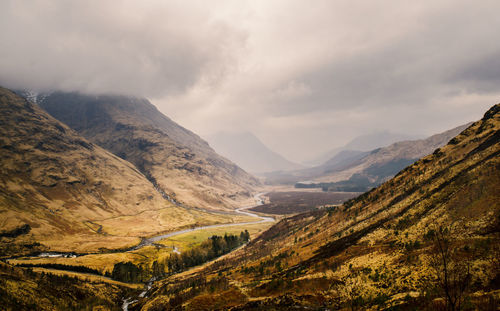 Scenic view of mountains against cloudy sky