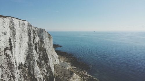 Calm blue sea against clear sky