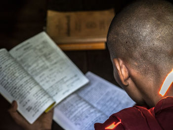 Close-up of man reading book