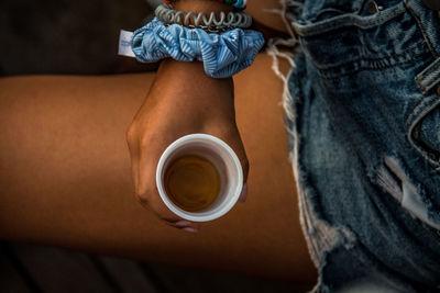 Midsection of woman holding coffee cup