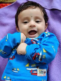 Portrait of cute baby boy relaxing on bed