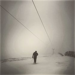 Rear view of man with birds on snow